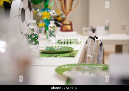 Kinderfußball- oder Fußball-Partytisch mit Plastikbesteck und Süßigkeiten. Festliche Dekoration zum Geburtstag, Boy Party. Geburtstagsgrüße. Stockfoto