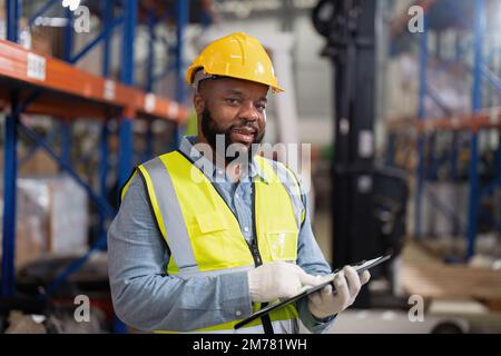 afroamerikaner, die im Lager arbeiten, überprüfen das Lade-Porträt von Gabelstaplern Stockfoto