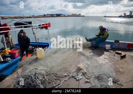 7. Januar 2023, Zarzis, Médenine governorate, Tunesien: Zarzis, Tunis. 07. Januar 2022 Ein Fischer bereitet seine Fischernetze vor, bevor er den Hafen von Zarzis im Südosten Tunesiens verlässt. Der Innenhafen des Hafens von Zarzis, eine tunesische Küstenstadt in der Nähe der libyschen Grenze, wird von Fischereifahrzeugen genutzt (Bild: © Hasan mrad/IMAGESLIVE via ZUMA Press Wire) Stockfoto