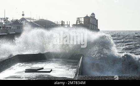 Brighton UK 8. Januar 2023 - riesige Wellen stürzen sich auf den Strand von Brighton und das Meer am Pier, während Stürme die Südküste heute mit einer Mischung aus starkem Wind, Sonnenschein und Regen treffen : Credit Simon Dack / Alamy Live News Stockfoto