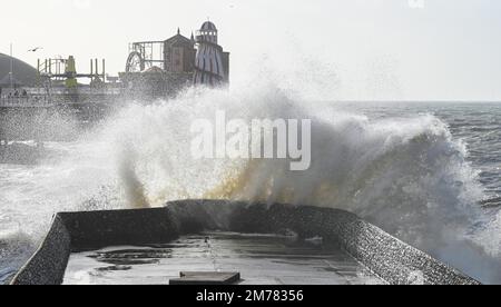 Brighton UK 8. Januar 2023 - riesige Wellen stürzen sich auf den Strand von Brighton und das Meer am Pier, während Stürme die Südküste heute mit einer Mischung aus starkem Wind, Sonnenschein und Regen treffen : Credit Simon Dack / Alamy Live News Stockfoto