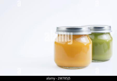 Baby-Gemüse- oder Fruchtpüree in einem Glasgefäß auf weißem Hintergrund. Babynahrungskonzept. Speicherplatz kopieren Stockfoto