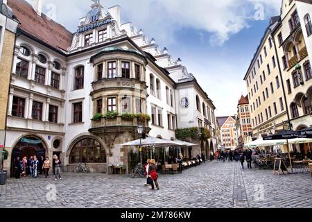 Touristen strömen in und aus der berühmten Hofbräuhaus in München, Deutschland. Stockfoto