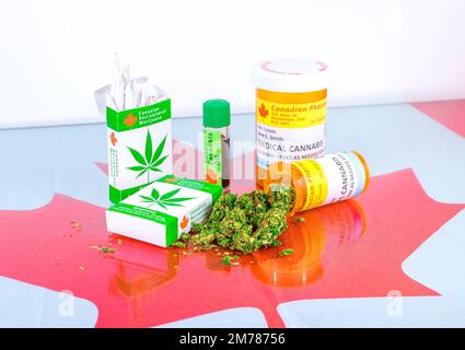 Cannabis in Kanada. Marihuana-Zigaretten, Cannabisöl und verschreibungspflichtige Flaschen für Cannabis auf einem Glastisch. Knospen laufen aus einer der Flaschen aus. Stockfoto