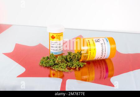 Cannabis in Kanada. Zwei Flaschen für Cannabis auf einem Glastisch mit einem roten Ahornblatt unter dem Glas. Eine Flasche liegt auf der Seite. Stockfoto