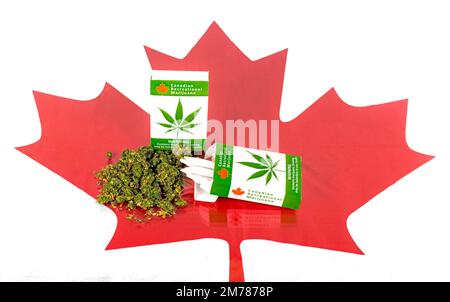 Cannabis in Kanada. Zwei Packungen Marihuana-Zigaretten mit Knospen, die auf einem Glastisch lagen. Ein Ahornblatt ist unter dem Glas. Die Gelenke stehen aus der Verpackung. Stockfoto