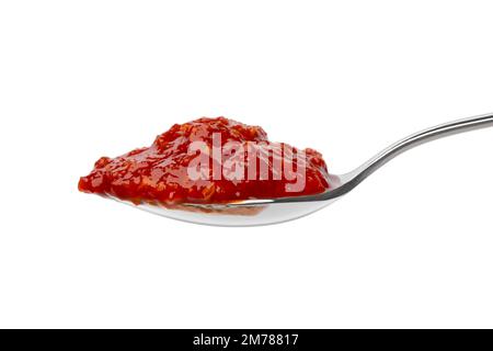 Metalllöffel mit rotem Sambal, indonesische Chilisauce, Nahaufnahme auf weißem Hintergrund Stockfoto