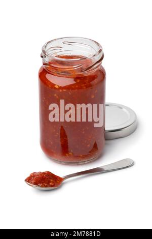 Glasbecher und Metalllöffel mit rotem Sambal und indonesischer Chilisauce, isoliert auf weißem Hintergrund Stockfoto