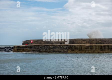 Wellen Sie über den weltberühmten Cobb bei Lyme Regis Dorset England, der in Jane Austens Roman Persuasion zu sehen ist Stockfoto