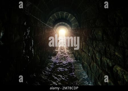 Alte historische gewölbte, überflutete unterirdische Entwässerungstunnel. Stockfoto