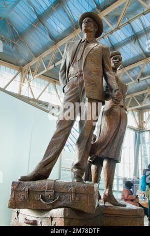 Das Bronze Sculpture National Windrush Monument wurde von Basil Watson, einer Familie, die auf einem Haufen Suitcases steht, in Waterloo Station London UK entworfen Stockfoto