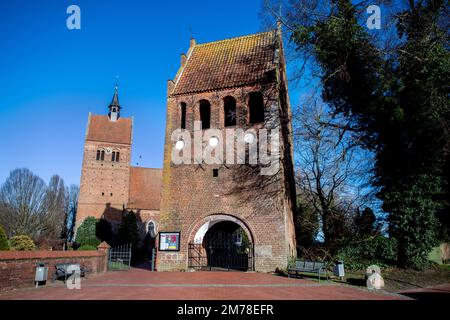 Bad Zwischenahn, Deutschland. 08. Januar 2023. Das historische St. John's Church und der dazugehörige freistehende Glockenturm stehen bei sonnigem Wetter auf dem Marktplatz im Stadtzentrum. Kredit: Hauke-Christian Dittrich/dpa/Alamy Live News Stockfoto