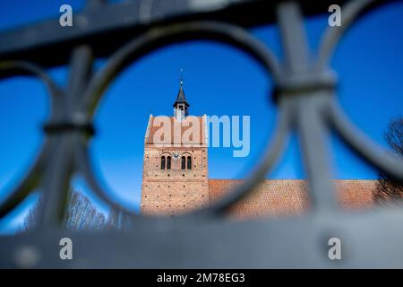 Bad Zwischenahn, Deutschland. 08. Januar 2023. Das historische St. John's Church steht bei sonnigem Wetter auf dem Marktplatz im Stadtzentrum, fotografiert durch einen gusseisernen Zaun. Kredit: Hauke-Christian Dittrich/dpa/Alamy Live News Stockfoto