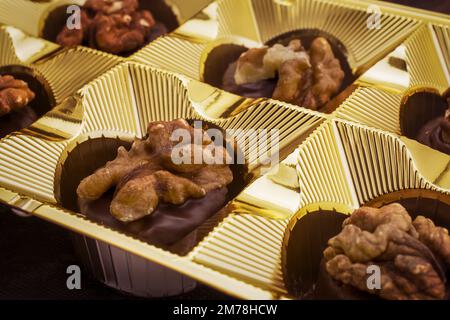 Nahaufnahme von hausgemachten Pralinen aus dunkler Schokolade gefüllt mit Walnuss Stockfoto