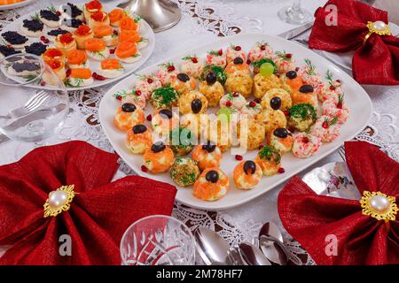 Partyessen, Weihnachtsbaum Kiwis Salat und verschiedene Würstchen Stockfoto