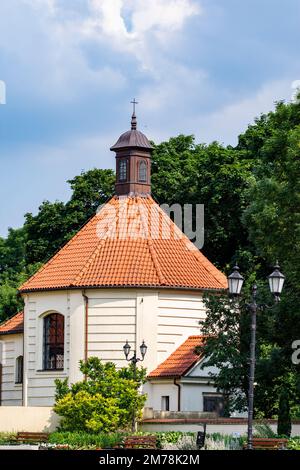 Haus oder Gebäude an einem sonnigen Tag verdeckt von grünen Bäumen. Sommer. Stockfoto
