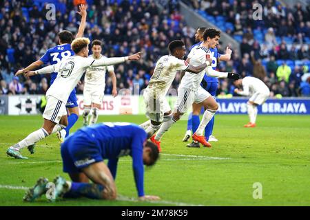 Sonny Perkins von Leeds United (rechts) feiert mit Teamkollegen das zweite Tor ihrer Seite des Spiels, während die Spieler von Cardiff City beim dritten Spiel des Emirates FA Cup im Cardiff City Stadium deprimiert erscheinen. Foto: Sonntag, 8. Januar 2023. Stockfoto