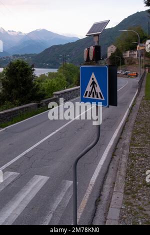 Verkehrszeichen für Fußgänger, ausgestattet mit solarbetriebener Warnleuchte auf einer Bergstraße. Stockfoto