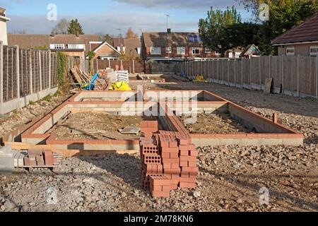 Neue freistehende Unterbaukonstruktion von Häusern Fortschritt rote Ziegel und Betonblöcke bilden tragende Wände auf Betongräben England UK Stockfoto