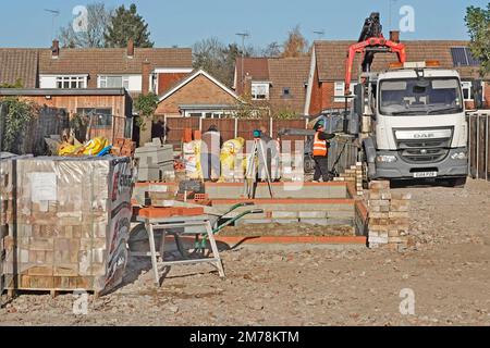 LKW-Fahrer an steuert Kranabladung lkw-Lkw mit Baumaterial Arbeiten auf dem Einfamilienhaus-Füllgelände England UK Stockfoto