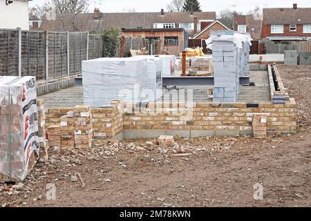 Kunststoffverpackungen auf Isolierblöcken und Ziegelsteinen Baumaterialien für den Bau eines neuen freistehenden Hauses auf dem Einfüllgelände UK Stockfoto