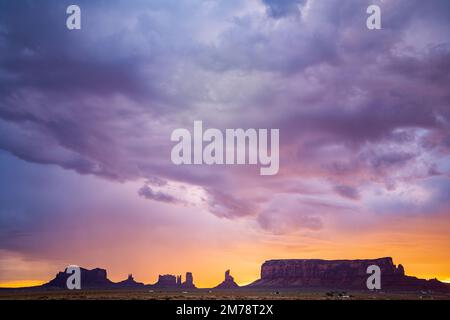 Farbenfroher Sonnenaufgang über den Silhouetten der Hügel im Monument Valley Stockfoto