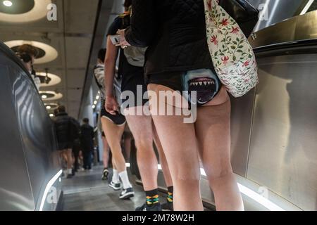 Menschen, die mit der U-Bahn fahren, nehmen an der 12. Jährlichen U-Bahn-Fahrt ohne Hosen in London Teil. Foto: Sonntag, 8. Januar 2023. Stockfoto