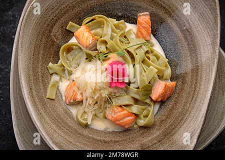 Grüne Pasta mit Lachs und Käse, im Dunkeln Stockfoto