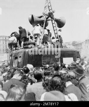 Feierliche Menschenmassen und lautes Lautsprechersystem auf der La Canabière Avenue bei einer Siegesparade in Marseille, Frankreich, am Tag nach der Kapitulation Deutschlands am Ende des Zweiten Weltkriegs am 8. Mai 1945. Klassisches Schwarz-Weiß- oder Schwarzweißbild, aufgenommen am 9. Mai 1945. Stockfoto