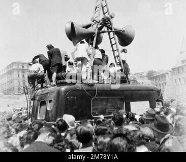 Feierliche Menschenmassen und lautes Lautsprechersystem auf der La Canabière Avenue bei einer Siegesparade in Marseille, Frankreich, am Tag nach der Kapitulation Deutschlands am Ende des Zweiten Weltkriegs am 8. Mai 1945. Klassisches Schwarz-Weiß- oder Schwarzweißbild, aufgenommen am 9. Mai 1945. Stockfoto