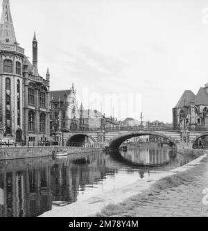 1960er Blick auf den Riverside Graslei Quay am Leie River und die mittelalterliche St. Michael's Bridge in der Altstadt oder dem historischen Viertel Gent Belgien c1960. Klassische Schwarzweiß- oder Schwarzweißfotos. Stockfoto