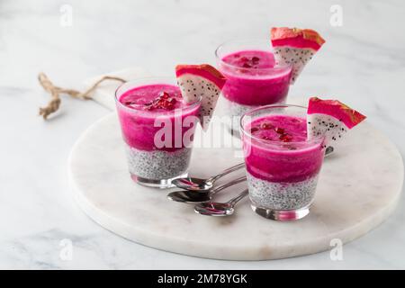 Chia-Puddings aus Drachenfrucht, garniert mit Drachenfruchtkeilen, verzehrfertig. Stockfoto