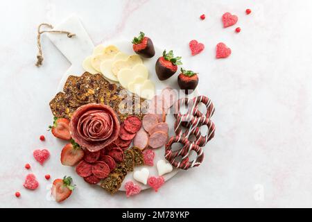 Ein rundes Valentinstagsaufschnitt-Brett vor hellem Hintergrund. Stockfoto