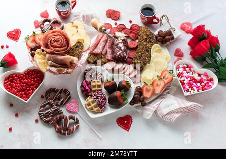 Ein Arrangement mit verschiedenen Leckereien und Snacks zum Valentinstag. Stockfoto