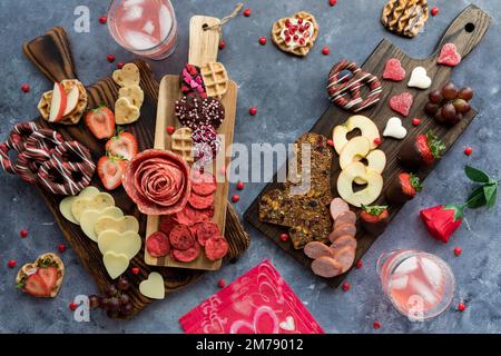 Charcuterie Boards am Valentinstag mit verschiedenen Leckereien und Snacks. Stockfoto