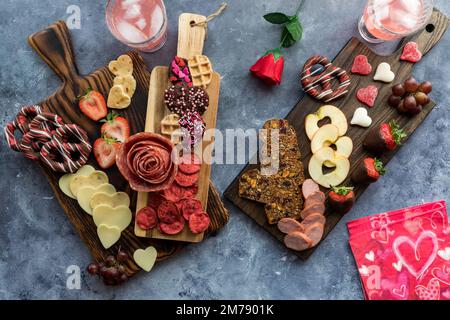 Charcuterie-Boards zum Valentinstag mit verschiedenen Leckereien und Snacks zum Teilen. Stockfoto