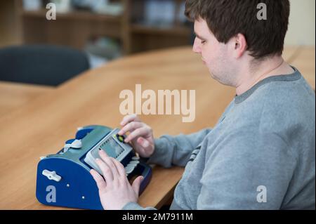 Blinder Mann mit Brailleschrift-Schreibmaschine. Stockfoto