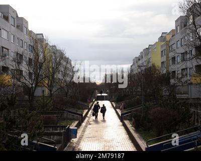 Berlin, Deutschland. 08. Januar 2023. Passanten gehen zwischen Wohngebäuden auf der Sonnenallee in der Hochdeck-Wohnanlage Neukölln. Dort, wie an vielen anderen Orten in der Stadt, eskalierte die Gewalt an Silvester. Unbekannte haben einen Bus in der Unterführung angezündet. Politiker, Polizei und verschiedene Verbände suchen nun nach Lösungen. Kredit: Paul Zinken/dpa/Alamy Live News Stockfoto