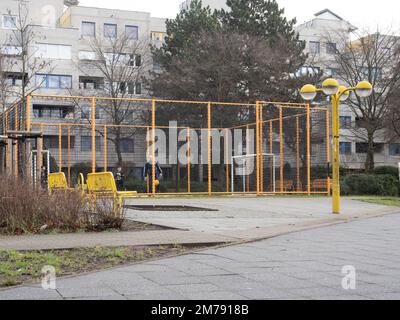 Berlin, Deutschland. 08. Januar 2023. Kinder und ein Mann spielen auf einem eingezäunten Fußballfeld unweit des Wohnsitzes in Neukölln. Dort, wie an vielen anderen Orten in der Stadt, eskalierte die Gewalt an Silvester. Politiker, Polizei und verschiedene Verbände suchen nun nach Lösungen. Kredit: Paul Zinken/dpa/Alamy Live News Stockfoto