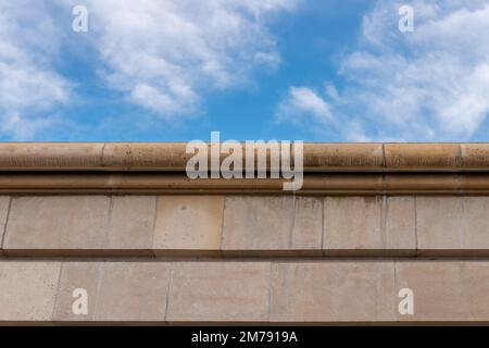 Steinmauer aus Dolomit am blauen Himmel. Rustikal und nett. Architektonische Details Stockfoto