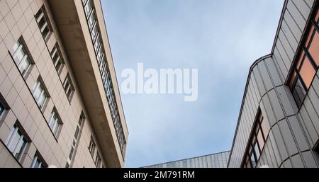 Blick auf modernistische Gebäude gegen den Himmel aus menschlicher Perspektive Stockfoto