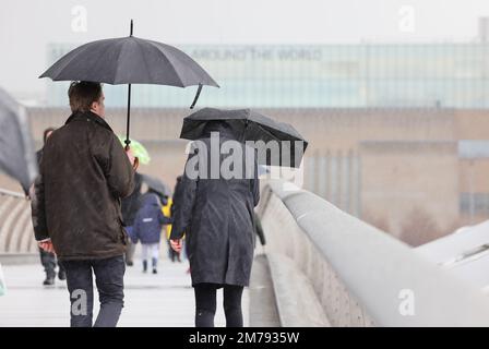 London, Vereinigtes Königreich, 8. Januar 2023. Touristen, die über die Millennium Bridge im Zentrum von London gingen, wurden von heftigen Regenfällen überrascht, da das unruhige Wetter im Januar anhält. Cedit:Monica Wells/Alamy Live News Stockfoto