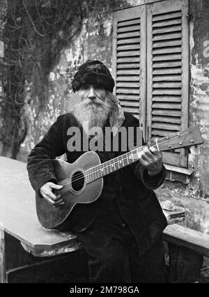 Frédéric Gérard - der Besitzer und Leiter des Lapin Agile, des berühmten Montmartre Kabaretts - 1927 - bärtiger Gitarrenspieler. Stockfoto