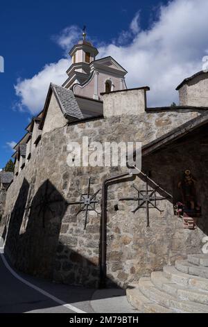 Sesto-Sexten, Italien - 19. September 2022 - Pfarrkirche St. Peter und St. Paul mit dem wunderschönen Friedhof mit Arkaden im Spätsommer Stockfoto