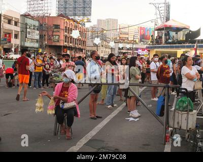 Manila, Philippinen. 08. Januar 2023. Gläubige stehen am Quezon Boulevard und hören der Messe in der Quiapo Kirche zu. Katholische Anhänger strömen in die Quiapo Kirche in Manila, um ihre Hingabe zum Schwarzen Nazarener auszudrücken, ein lebensgroßes Bild von dunkel gehäutetem, knienden Jesus Christus mit dem Kreuz. Einen Tag vor dem Festmahl am 9. Januar. Diese festliche Aktivität wurde wegen der COVID-19-Pandemie für zwei Jahre ausgesetzt. (Foto: Josefiel Rivera/SOPA Images/Sipa USA) Guthaben: SIPA USA/Alamy Live News Stockfoto