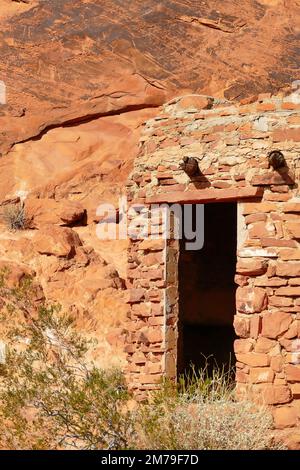 Tür zu einer alten Sandsteinhütte im Valley of Fire State Park, Nevada, USA. Auf dem Felsgesicht über der Tür alte indianische Felszeichnungen. Stockfoto