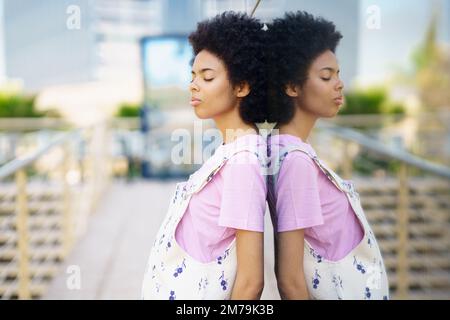 Ruhige schwarze Frau in der Nähe des Glashauses Stockfoto