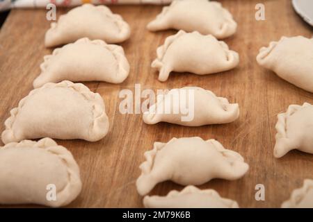 Hausgemachte, handgemachte Knödel auf rustikalem Hintergrund mit Kräutern Stockfoto