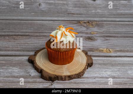 Auswahl an Schokolade-, Sahne- und Karotten-Cupcakes mit verschiedenen Hintergründen Stockfoto