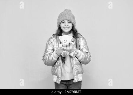 Positives Kind trägt warme Kleidung auf blauem Hintergrund. Stockfoto